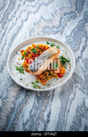 Gebratenes Lachsfilet mit Kürbis- und Süßkartoffel-Rösti-Gratin auf einem Teller serviert Stockfoto