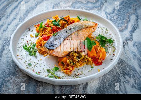Gebratenes Lachsfilet mit Kürbis- und Süßkartoffel-Rösti-Gratin auf einem Teller serviert Stockfoto