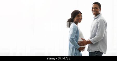 Liebevolle Erwartung schwarzes Paar posiert über weißem Hintergrund Stockfoto