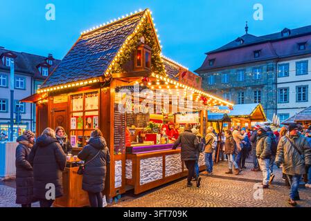 Bamberg, Deutschland – 28. November 2025. Menschenmenge an einem beleuchteten Glühweinstand auf dem Bamberger Markt in Bayern. Stockfoto