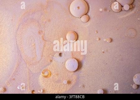 Gold- und rosa Fluid Art erzeugt einen abstrakten Hintergrund mit schimmernder Textur, Wirbeln und leichten Flüssigkeitsblasen Stockfoto
