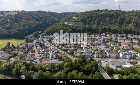 Luftbild von Häusern, Uferstraßen und einer Brücke über die Altmühl unter bewaldeten Hügeln und freiliegendem Fels in Eichstätt, Oberbayern, Deutschland. Stockfoto
