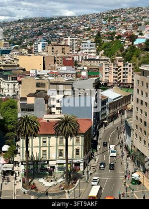 Valparaiso, Chile - 14. Oktober 2026: Luftaufnahme der dichten städtischen Hügellandschaft mit Palmen auf einem kleinen Platz, gewundenen Straßen und Ci Stockfoto