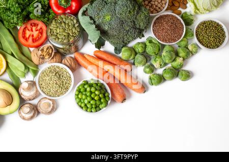 Fülle an frischem Bio-Gemüse, Hülsenfrüchten und gesunden Samen, arrangiert auf weißem Hintergrund mit Kopierraum Stockfoto