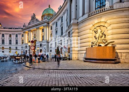 Fiaker Pferdekutschen und Besucher auf dem Michaelerplatz, während am kaiserlichen Palastflügel ein Weihnachtsbaum aufgestellt wird, Österreich Stockfoto