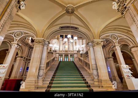 Marmorneu-renaissance-Treppe mit grünem Teppich und vergoldeter gewölbter Decke, die zur Logenebene der Wiener Staatsoper in Wien führt. Stockfoto