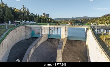 Niedzica, Polen – 19. September 2026: Luftaufnahme des Czorsztyn-Staudamms mit einer Fußgängerbrücke, Spaziergängern, dem Stausee und dem Schloss Niedzica im Stockfoto