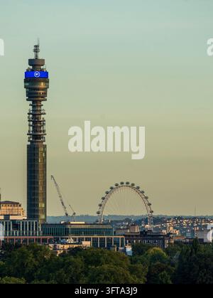 BT Tower und das London Eye erheben sich über Baumwipfeln im sanften Abendlicht, gesehen vom Primrose Hill Stockfoto