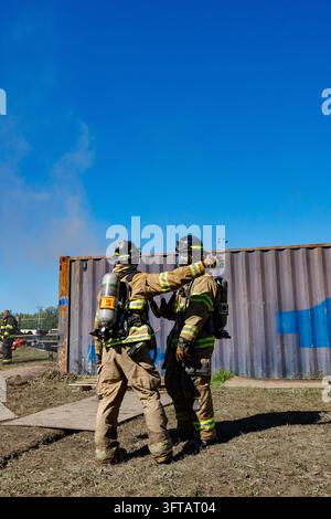 Merrionette Park, IL, USA - 2. Oktober 2026: Feuerwehrleute nehmen an Trainingseinheiten an einer Outdoor-Akademie teil. Sie arbeiten zusammen, während sie eq tragen Stockfoto
