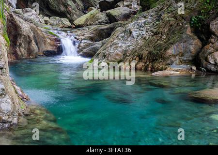 Klares Smaragdwasser des Sanzhanxi-Baches in Hualien. Ein kleiner Wasserfall fließt in ein Bergbecken. Schöne felsige Landschaft in Taroko, Taiwan. Stockfoto
