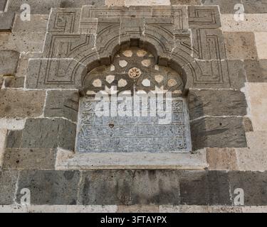 Detaillierte Ansicht von Steinmauerwerk, kunstvollen geometrischen Schnitzereien und arabischer Kalligraphie an der Außenwand der Alaeddin-Moschee in Konya, Türkei Stockfoto