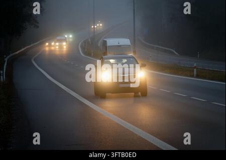 Autos im Nebel. Schlechtes Wetter und gefährlichen Autoverkehr auf der Straße. Light Vehicles in nebligen Tag. Stockfoto