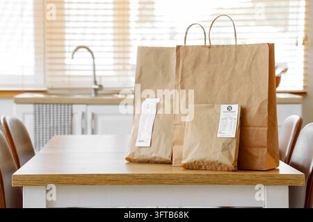 Lebensmittellieferung und Lebensmitteleinkäufe, Papiertüten mit Quittungen auf einem Küchentisch für die Zubereitung von Hausmannskost und nachhaltige Verbrauchergewohnheiten Stockfoto