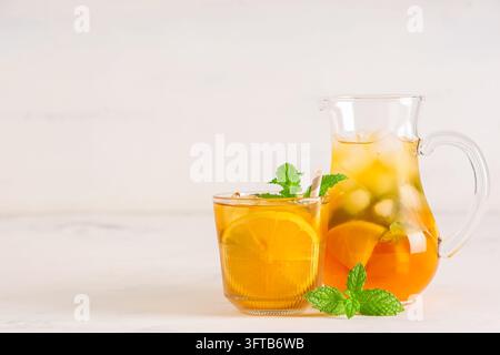 Erfrischender Eistee mit Zitrone und Minze, Sommergetränk und gesundes Trinkkonzept, kaltes Getränk in Glaskrug und Tumbler auf hellem Hintergrund Stockfoto
