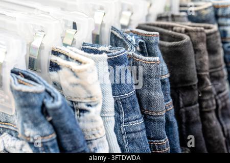 Viele blaue Jeans auf Kleiderbügel für Verkauf in den lokalen Markt in Thailand, Nahaufnahme Stockfoto