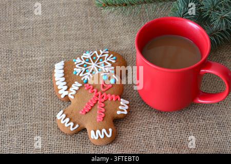 Lebkuchenmann und Fausthandschuh-Kekse mit Kaffeetasse auf Sackleinen, Blick von oben Stockfoto