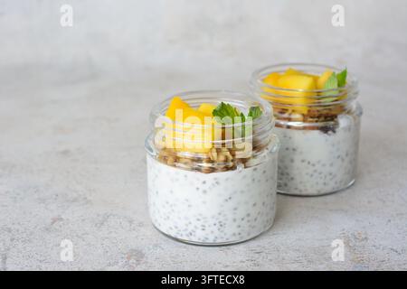 Chia-Pudding mit gewürfeltem Mango und Granola in Gläsern, Kopierraum Stockfoto