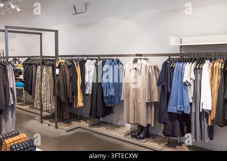 Damenbekleidung hängt an Metallstangen in einem Modegeschäft Stockfoto