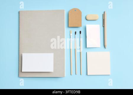 Mockup Flat Lay mit verschiedenen Büroaccessoires auf blauem Hintergrund Stockfoto