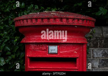 Rote Dorfbriefkasten in Großbritannien Stockfoto
