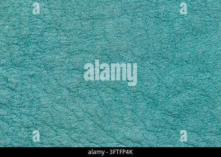 Nahaufnahme einer lebendigen blaugrünen Wildledertextur mit einem samtig weichen Flor und einem feinen Körnungsmuster, die eine kühle und erfrischende Ästhetik bietet. Stockfoto