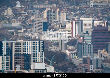 Luftaufnahme eines vielfältigen Stadtviertels in Seoul mit einem grünen Baukran inmitten einer dichten Mischung aus mittelhohen Gewerbe- und Wohngebäuden.. Stockfoto