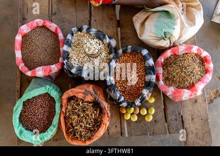 Ansicht von oben auf offene Säcke gefüllt mit Bohnen, Erdnüssen, getrocknetem Fisch und Zitronen an einem Marktstand, Menabe, Tsiribihina, Madagaskar Stockfoto