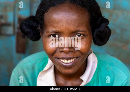 Nahaufnahmeporträt einer lächelnden malagassischen Frau mit ihren Haaren zu zwei runden Knoten frisiert, Melaky, Bekopaka, Madagaskar Stockfoto