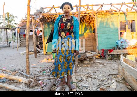 Vezo-Frau, die eine traditionelle Gesichtsmaske trägt, steht zwischen Holzbootrahmen im Dorf, Menabe, Belo sur Mer, Madagaskar Stockfoto