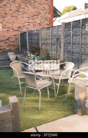 Kleiner privater Garten mit Außentisch und Stühlen im britischen Wohnhof Stockfoto