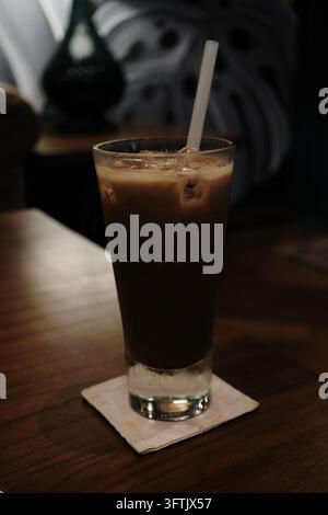 Glas Eiskaffee auf einem Holztisch in einem Café. Stockfoto