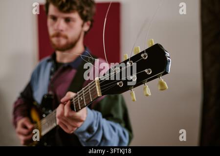 Mann spielt E-Gitarre während der Bandprobe im Studio Stockfoto
