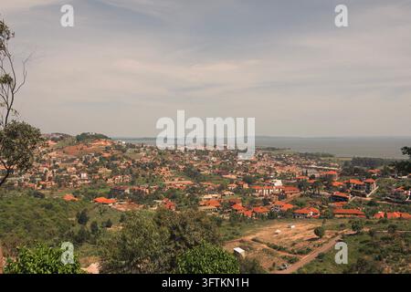 Eine Panoramar Ansicht der dichten Wohngebiete und der markanten rotgedeckten Häuser, die sich über die Hügel und die grüne Landschaft von Kampala erstrecken Stockfoto