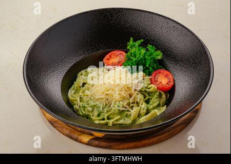 Fettuccine-Pasta mit grüner Pesto-Sauce und Tomaten Stockfoto