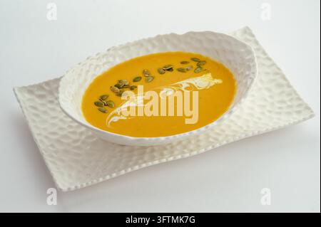 Cremige Butternusskürbissuppe mit Pepitas und Sahne Stockfoto