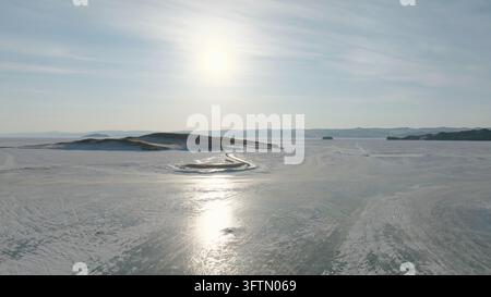 Eine weitläufige Winterluftaufnahme zeigt die gefrorene Maloye-More-Strasse, schneebedeckte Inseln und musteriges Eis am Baikalsee im Irkutsker Gebiet, Russland Stockfoto
