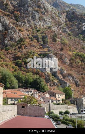Alte Steinmauern und Befestigungen einer Stadt, die sich die steilen, felsigen Hänge des Berges Saint John in Kotor, Montenegro, hinaufschlängeln Stockfoto