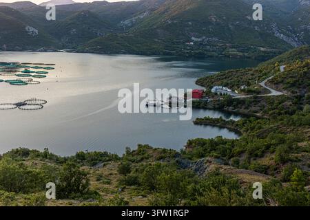 Albanien, Shpor 2026 07 24: Kilic Fish Farm - Aquakultur-Käfige der Kilic Fish Farm auf einem Bergsee, Blick von oben. Stockfoto