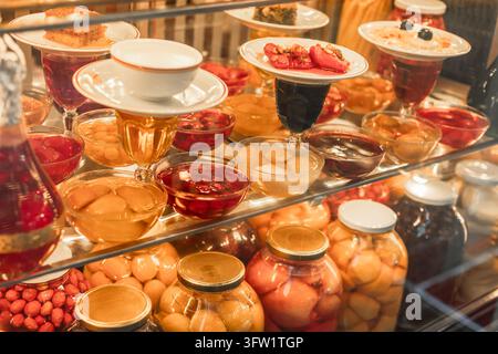 Türkei, Istanbul 2025 10 03: Verschiedene traditionelle türkische Desserts, eingelegte Früchte und Marmeladen, die in einem Restaurantvitrin auf Glasregalen präsentiert werden, ca Stockfoto