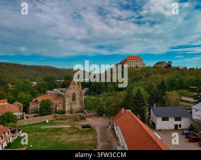 Luftbild des historischen Rosa-Coeli-Klosters in Dolní Kounice, Südmähren, Tschechien. Der mittelalterliche gotische Klosterkomplex ist von üppigen grünen Wäldern und sanfter Landschaft umgeben, mit dem Schloss Dolni Kounice auf dem Hügelgipfel im Stockfoto
