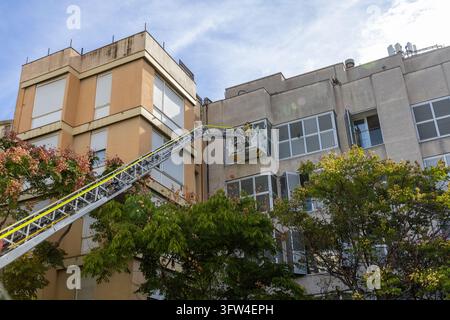 SABADELL, SPANIEN - 11. OKTOBER 2026: Ein Feuerwehrmann, der im Korb eines Hubrettfahrzeugs steht, streckt die Teleskopleiter diagonal über die Stockfoto
