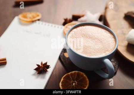Heiße Schokolade in einer blauen Tasse mit natürlichen Weihnachtsdekorationen Stockfoto