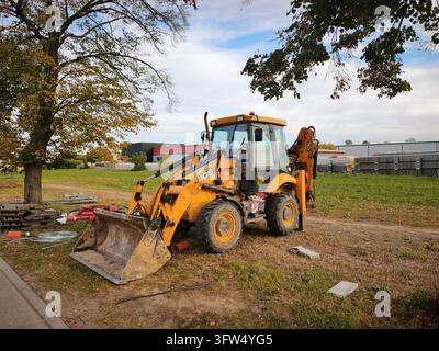 Slapanice, Tschechische Republik - 17. Oktober 2026: gelbe Baggerlader, die auf Gras geparkt ist Stockfoto