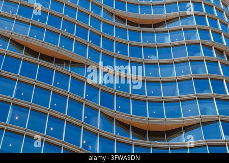 Glasfenster und gebogene Fassadenpaneele bedecken ein Bürogebäude in der Innenstadt von Vancouver, British Columbia, Kanada, bei Tageslicht. Stockfoto