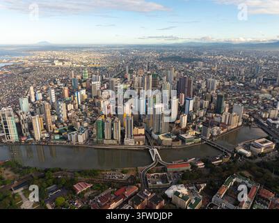 Luftaufnahme von Manila, Philippinen, zeigt moderne Wolkenkratzer und überfüllte Wohngebiete, die sich im Pasig River spiegeln und ein ikonisches Bild ergeben Stockfoto