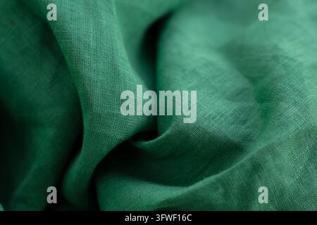 Zufällig platzierte dunkle frühlingsgrüne Leinenstoff. Minimal. Schmale Tiefenschärfe. Kopierraum. Stockfoto