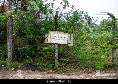 Rostiges Schild an einem Stacheldrahtzaun vor dichter Vegetation, Nordprovinz, Jaffna, Sri Lanka Stockfoto