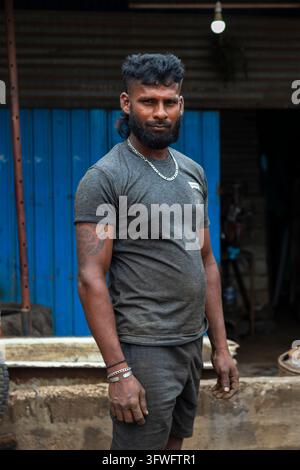 Bärtiger Mann steht vor einer blauen Metalltür, Nordprovinz, Jaffna, Sri Lanka Stockfoto