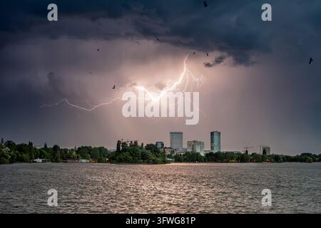 Ansicht eines dramatischen Blitzeinschlags, der die dunklen Gewitterwolken über der Stadtsilhouette und dem Herastrau-See in Bukarest, Bukarest, Rumänien, beleuchtet Stockfoto