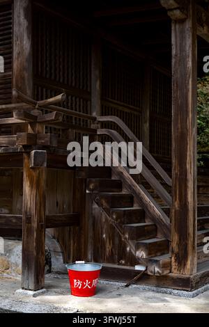 Moderner roter Metall-Feueimer aus Japan gefüllt mit Wasser, bereit, Flammen bei einem Brand im Mii-dera-Tempel in Otsu, Japan, zu löschen. Stockfoto
